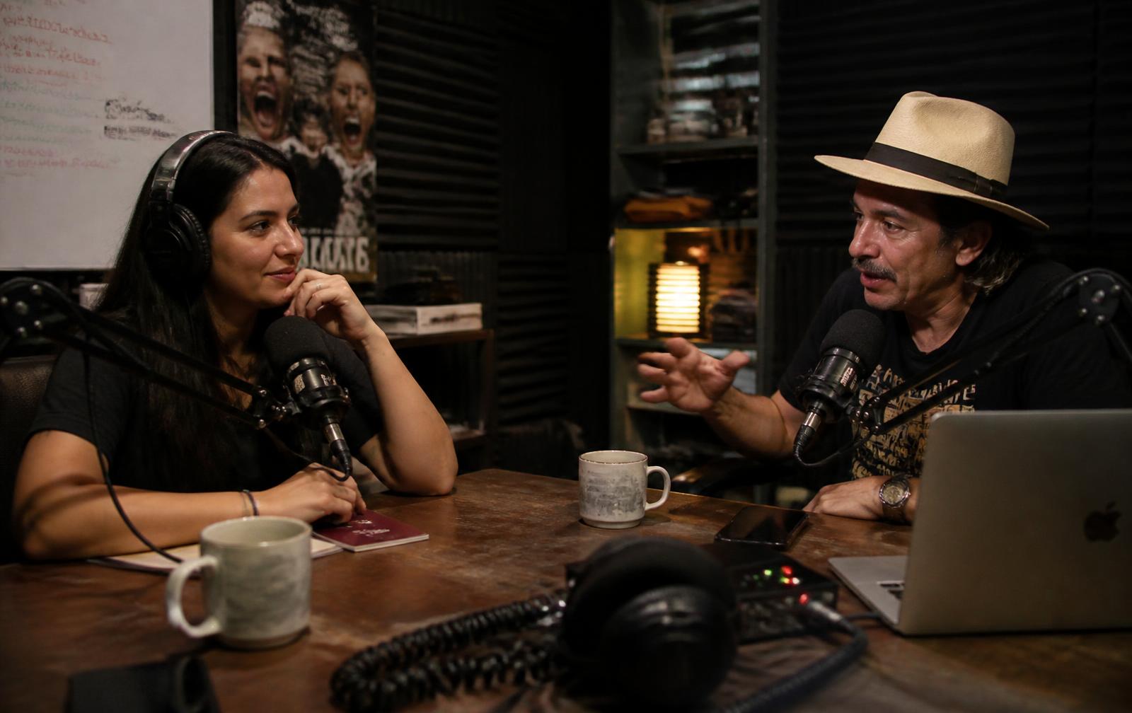 Estudio de grabación de podcast en penumbra con micrófonos y luz cálida