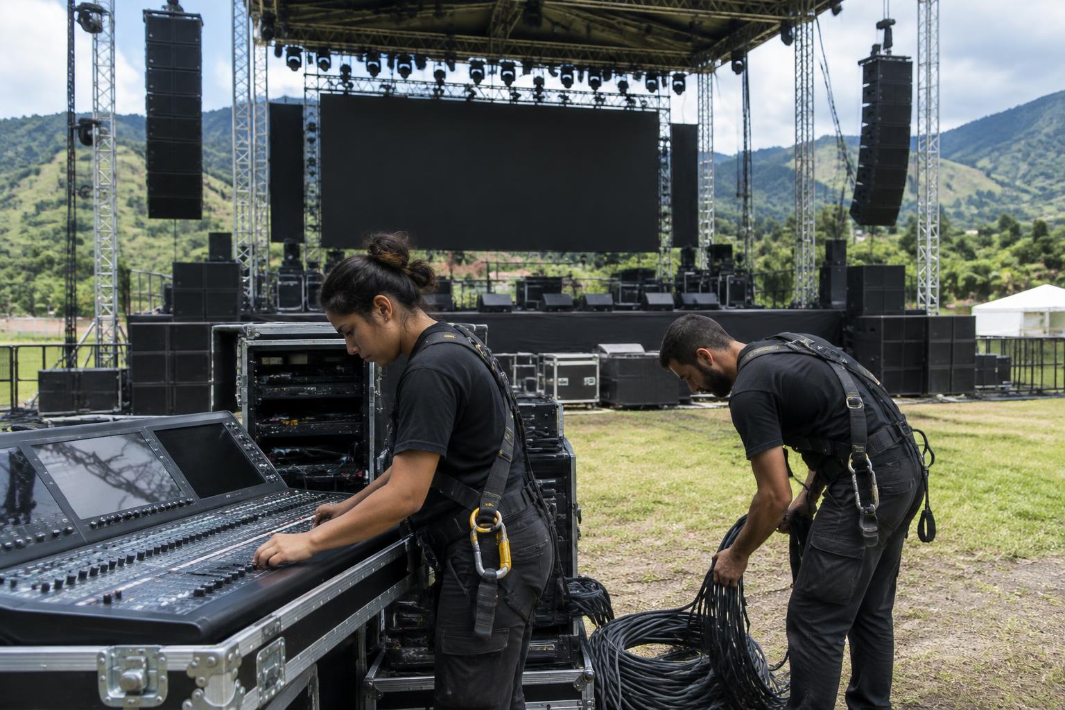 Montaje de tarima, truss y line array al atardecer antes de un concierto