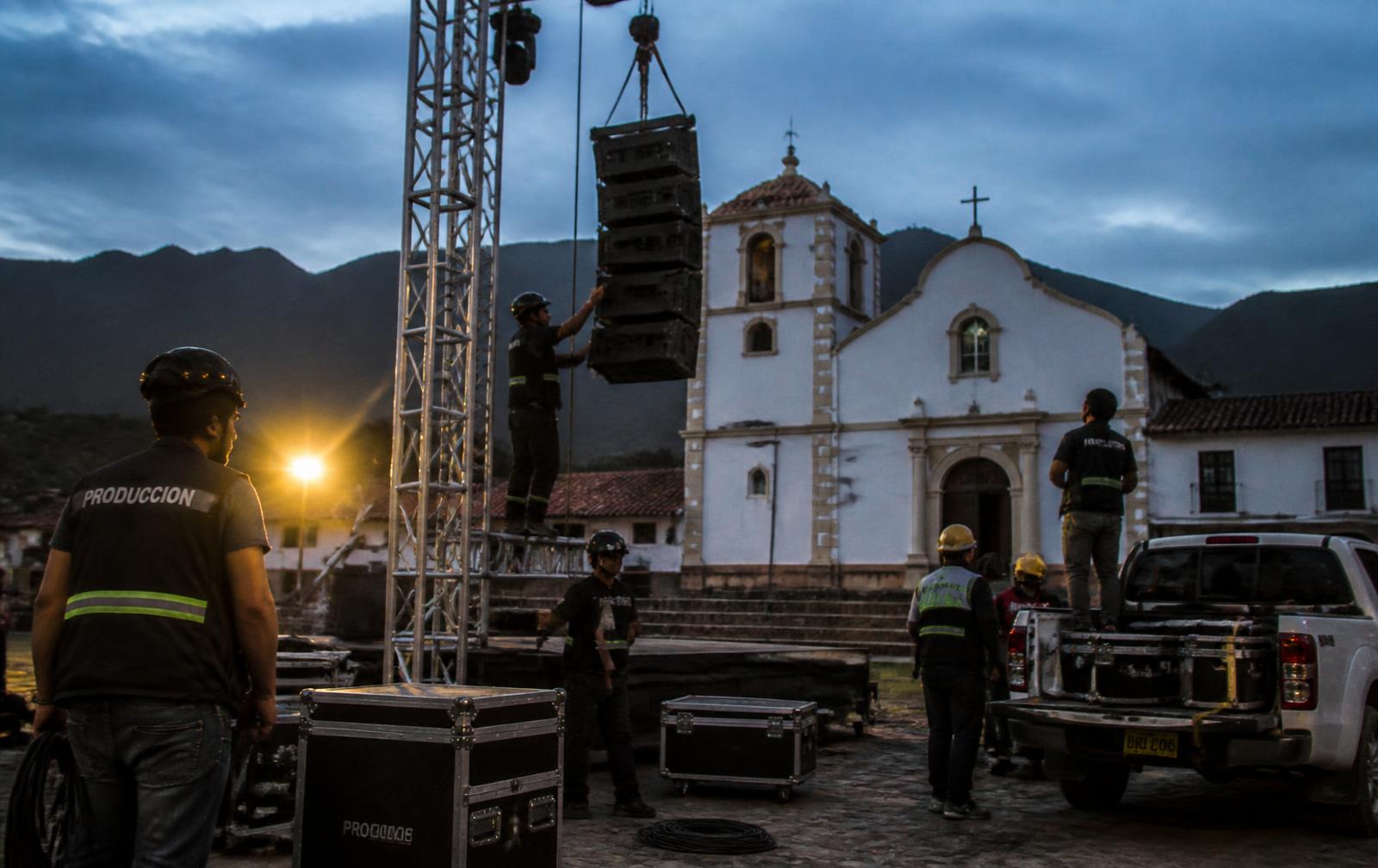 Montaje de tarima, truss y line array al atardecer antes de un concierto